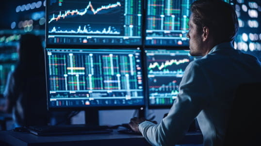 Analyst studies financial data on screens, leveraging StoneX Pro for deep liquidity