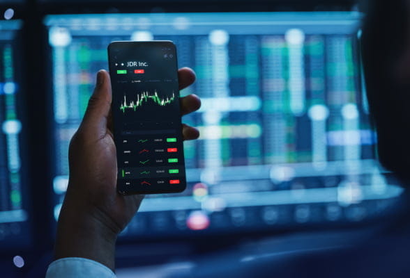 Financial professional accesses live FX chart on StoneX Pro trading ecosystem with his phone